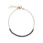 Pulsera de plata de ley bañada en oro con cordón y piedras de cristal negro.